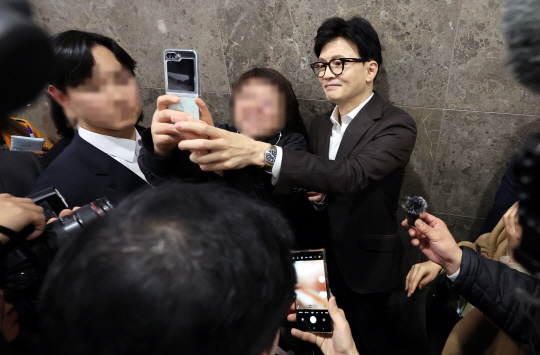 한동훈 법무부 장관이 지난 12월13일 오후 경기 성남시청에서 열린 '교정시설 수용자 의료처우 개선 및 공공보건의료 서비스 확대를 위한 업무협약' 협약식을 마친 뒤 현장에 있던 지지자들과 사진을 찍고 있다.<연합뉴스>